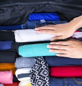 Menggulung pakaian saat packing
