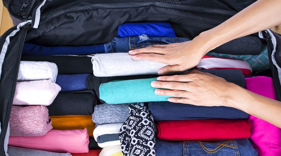 Menggulung pakaian saat packing